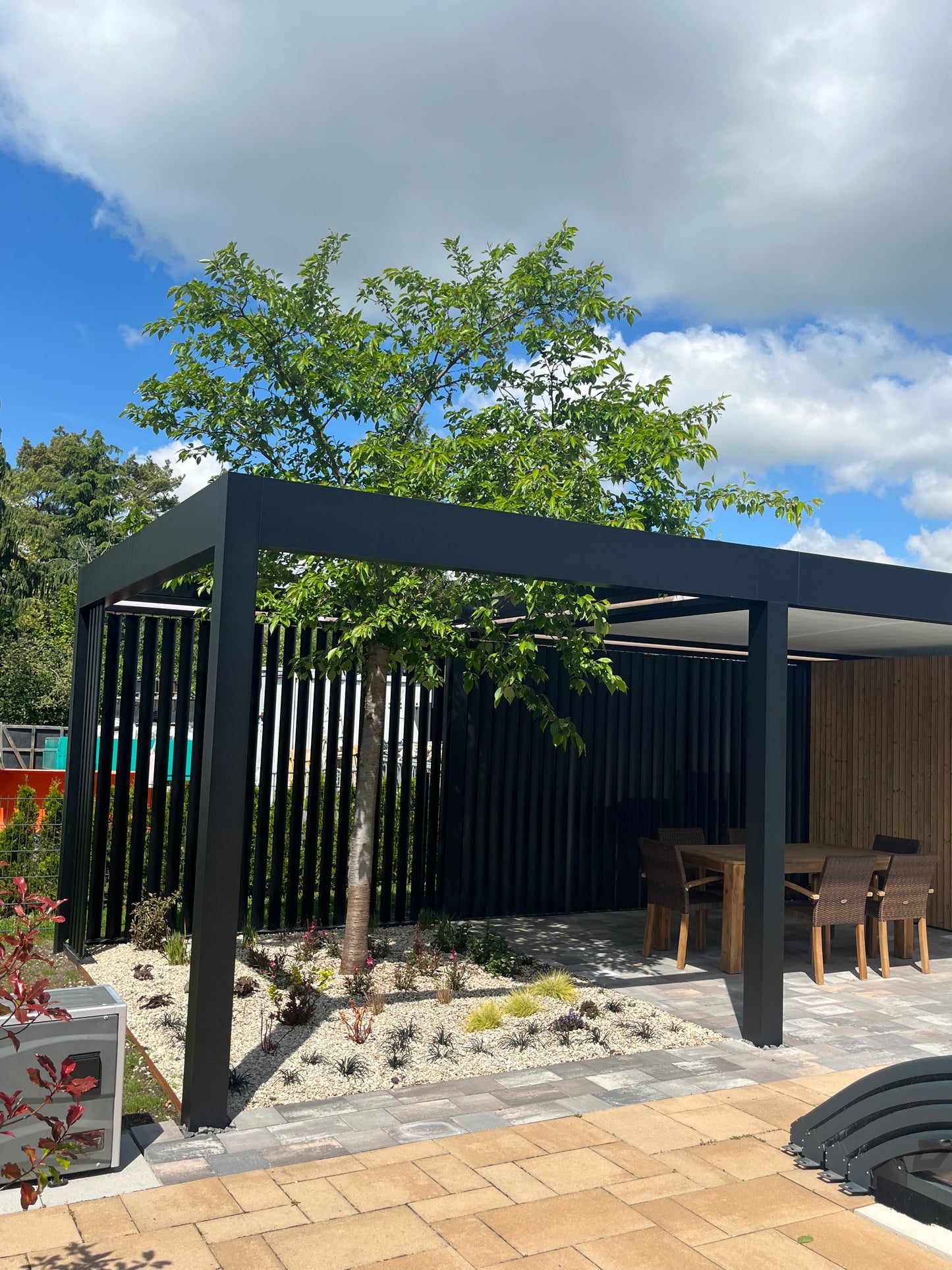 Aperto pergola in anthracite freestanding on a level garden, all four posts visible