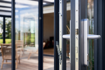 Roma Vista glass doors in anthracite on a wide veranda, panels stacked to master door