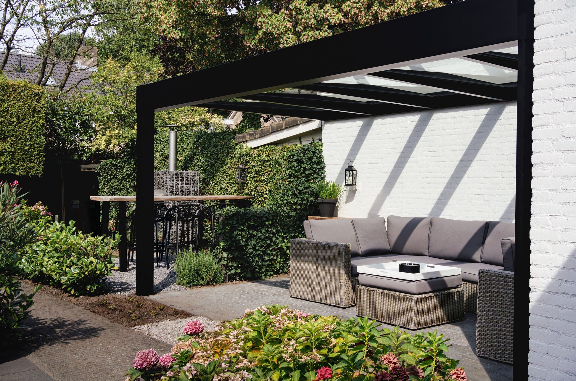 Cristallo pergola in anthracite wall-mounted, outdoor furniture positioned below