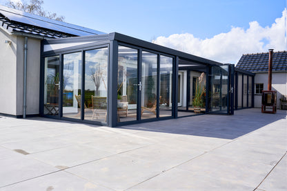 Slide and turn glass door in anthracite on a veranda, panels partially folded open