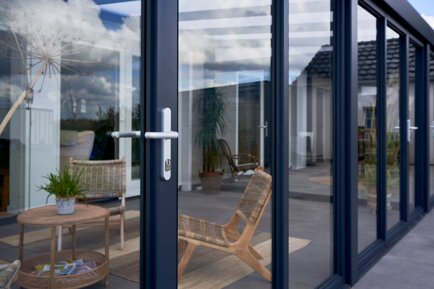 Slide and turn glass door in anthracite installed on a Giallo wide-span veranda