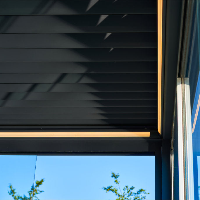 Aperto motorised pergola with integrated LED kit active at dusk, illuminating terrace below