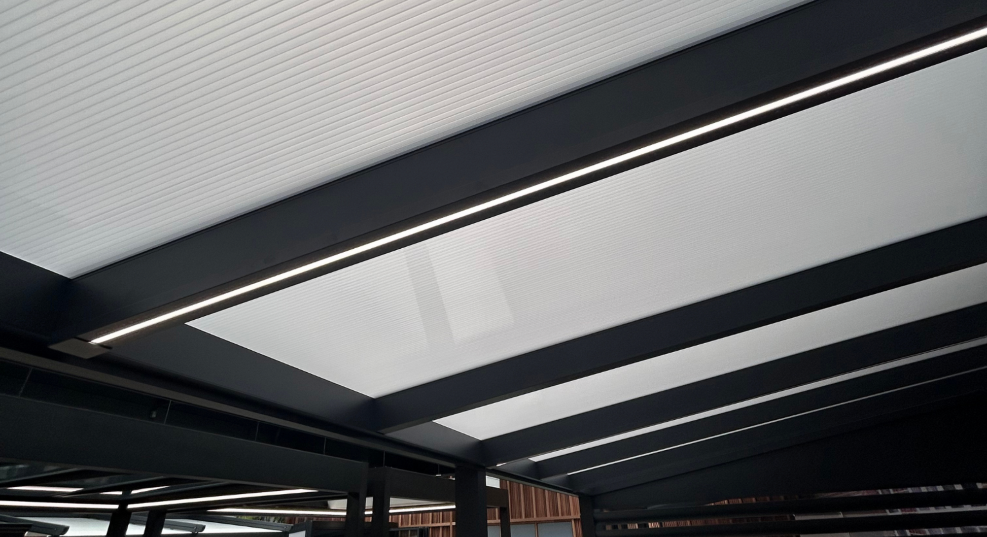 LED strip lighting installed in a veranda beam, warm white 2700K glow along the rafter