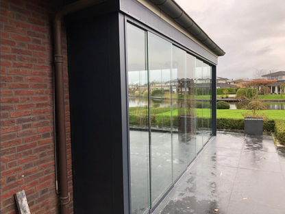 Modular aluminium panel in white used as a garden side wall adjacent to a veranda