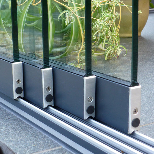 Frameless glass sliding door set in anthracite, panels slid fully open
