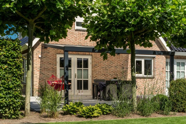 The Luxa veranda in black on a contemporary brick home, rear elevation