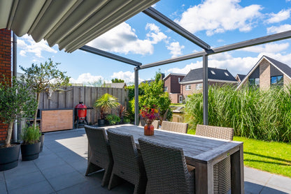 The Libero veranda in anthracite covering a dining terrace, fabric roof closed