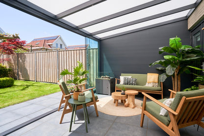 Luxa veranda in anthracite covering a large rear terrace with outdoor furniture