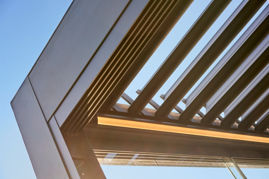 The Aperto pergola in anthracite freestanding in a rear garden, panels fully open