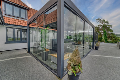 Aperto pergola in anthracite at dusk, LED-lit terrace below, panels closed