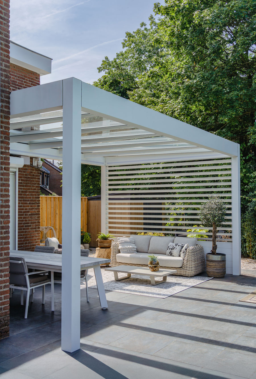 Cristallo pergola in anthracite at golden hour, natural light through glass roof above