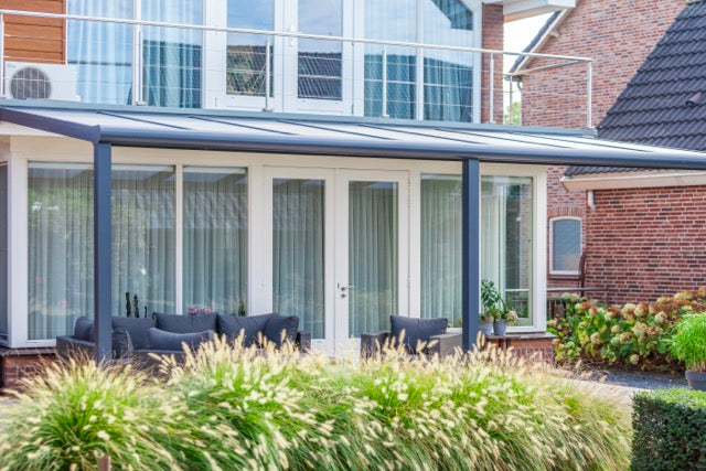 Wide Cascina veranda in anthracite spanning the full rear elevation of a detached home