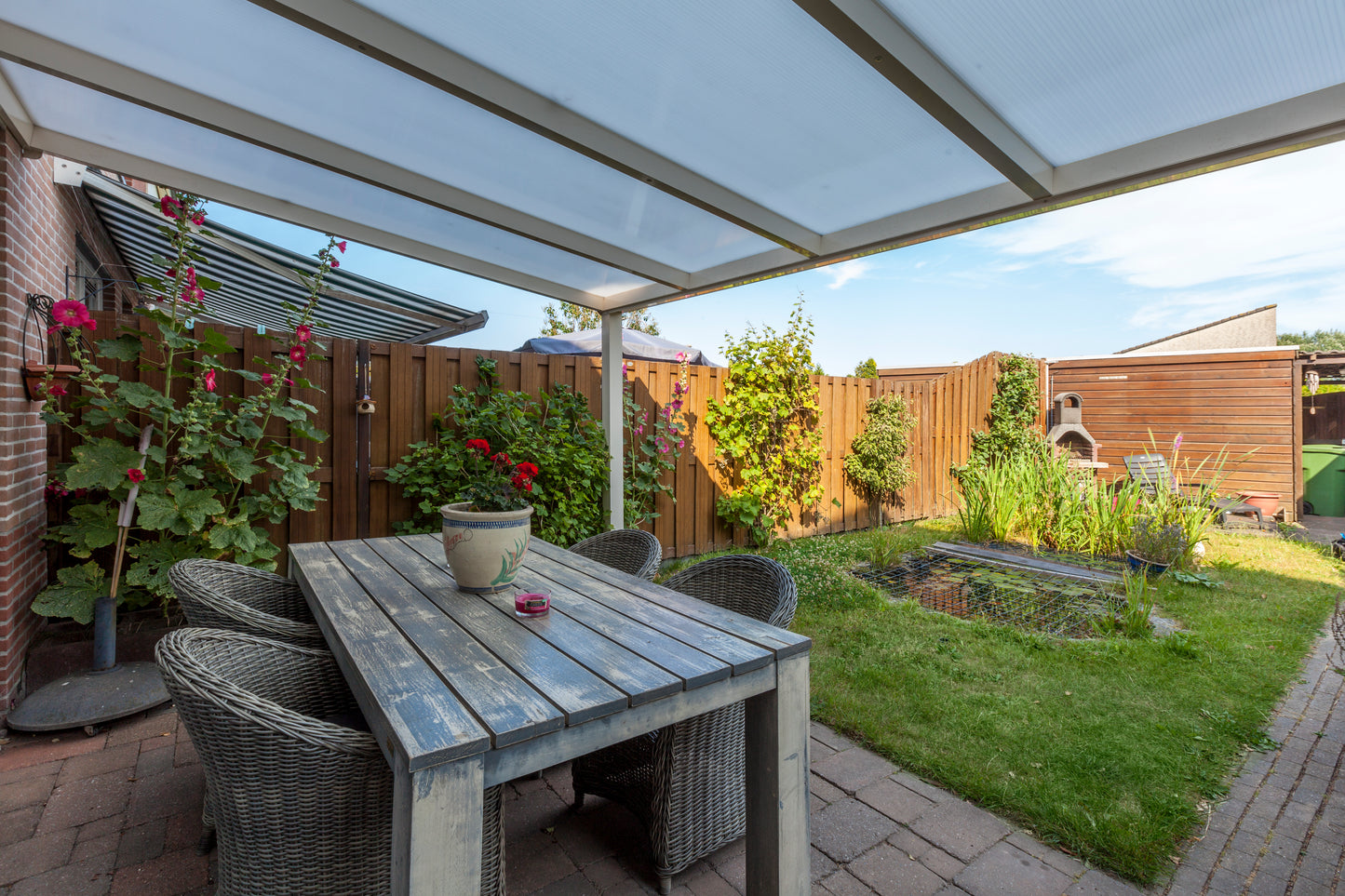 Cascina veranda in anthracite with outdoor lounge furniture positioned underneath