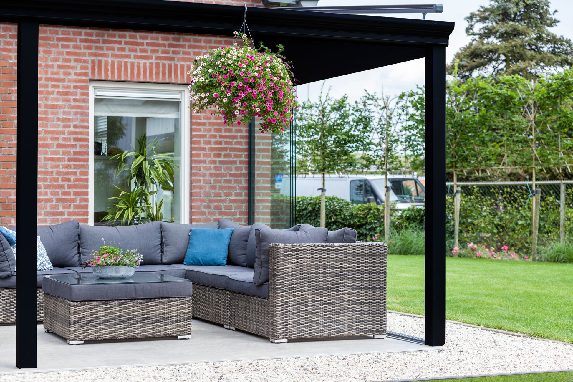 The Nobile veranda in anthracite at mid-morning, garden furniture arranged below